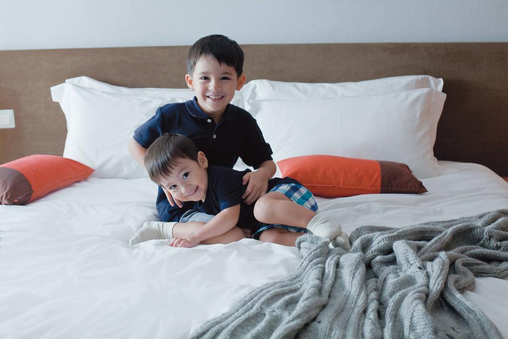 Fraser Place Robertson Walk Singapur Exterior foto Two children playing on a bed